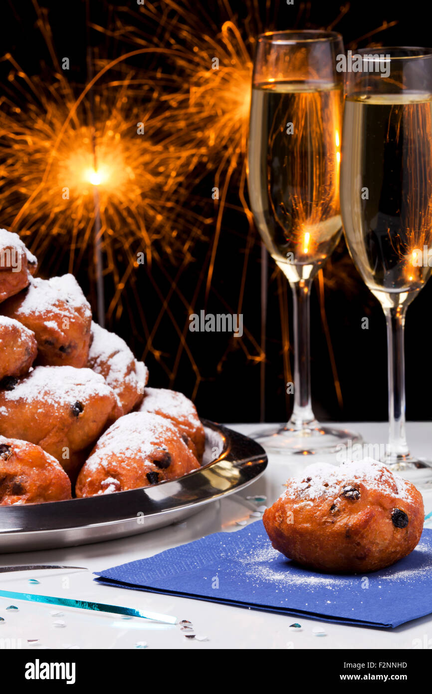 "Oliebollen', tradizionale pasticceria olandese per la Vigilia di Capodanno e due bicchieri di champagne. Foto Stock