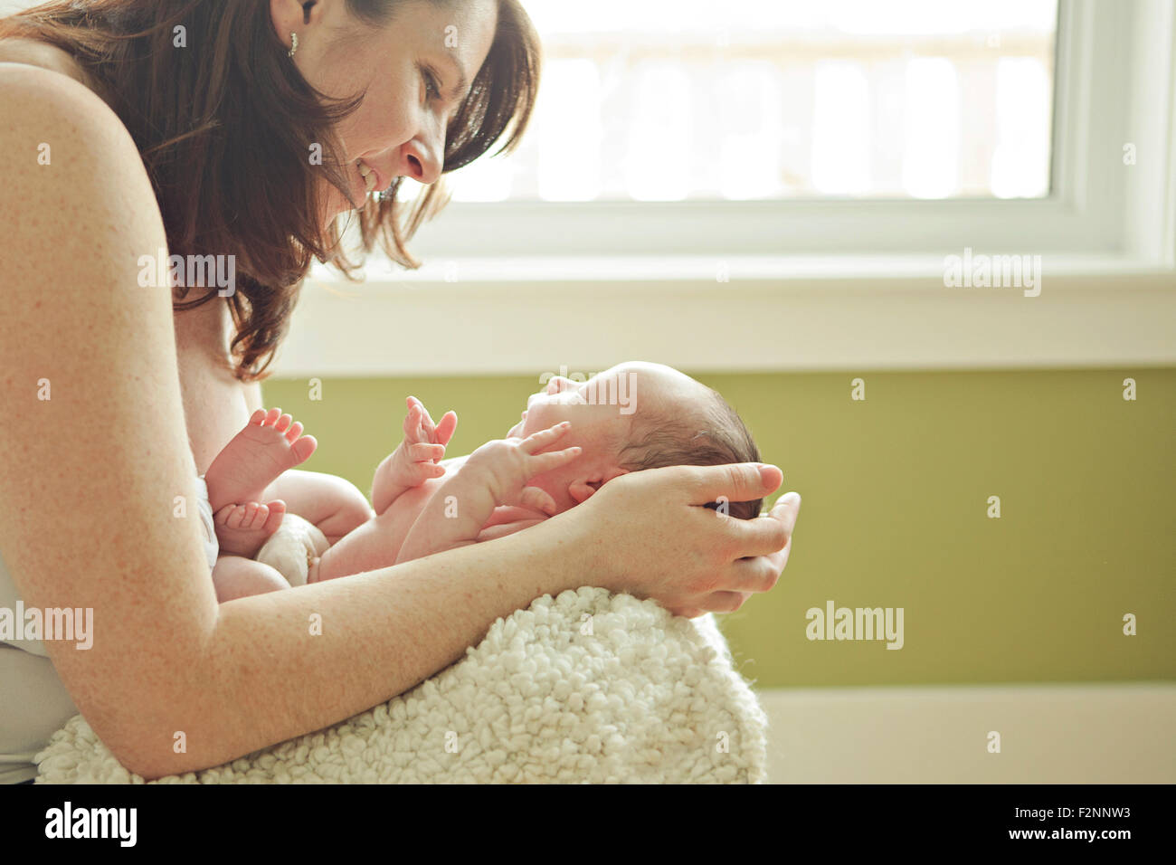 Madre caucasica holding neonato Foto Stock