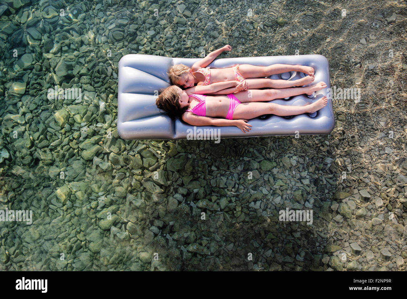 Ragazze caucasica galleggiante su zattera nel lago Foto Stock