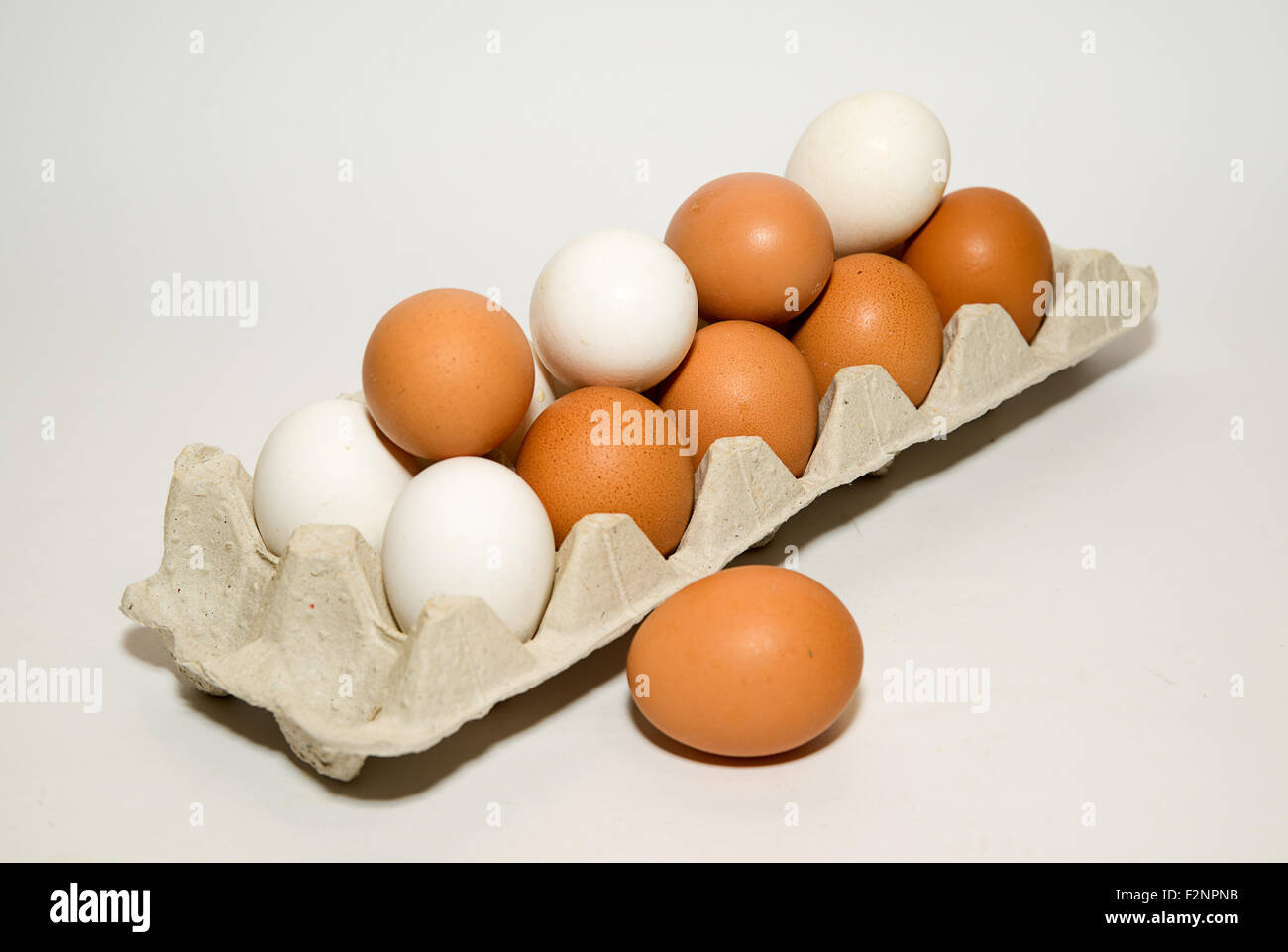Uova di gallina di diversi colori nella confezione su su bianco Foto Stock