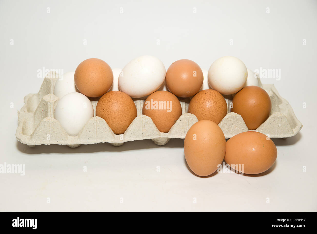 Uova di gallina di diversi colori nella confezione su su bianco Foto Stock