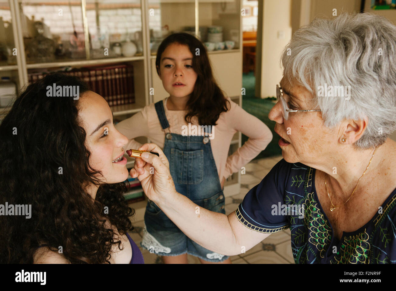 Nonna rossetto al nipote in sala da pranzo Foto Stock