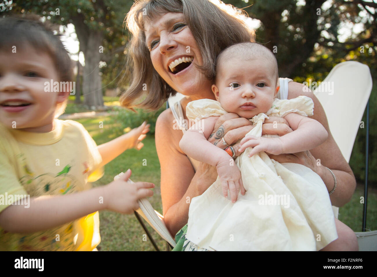 Nonna a giocare con i nipoti in cortile Foto Stock