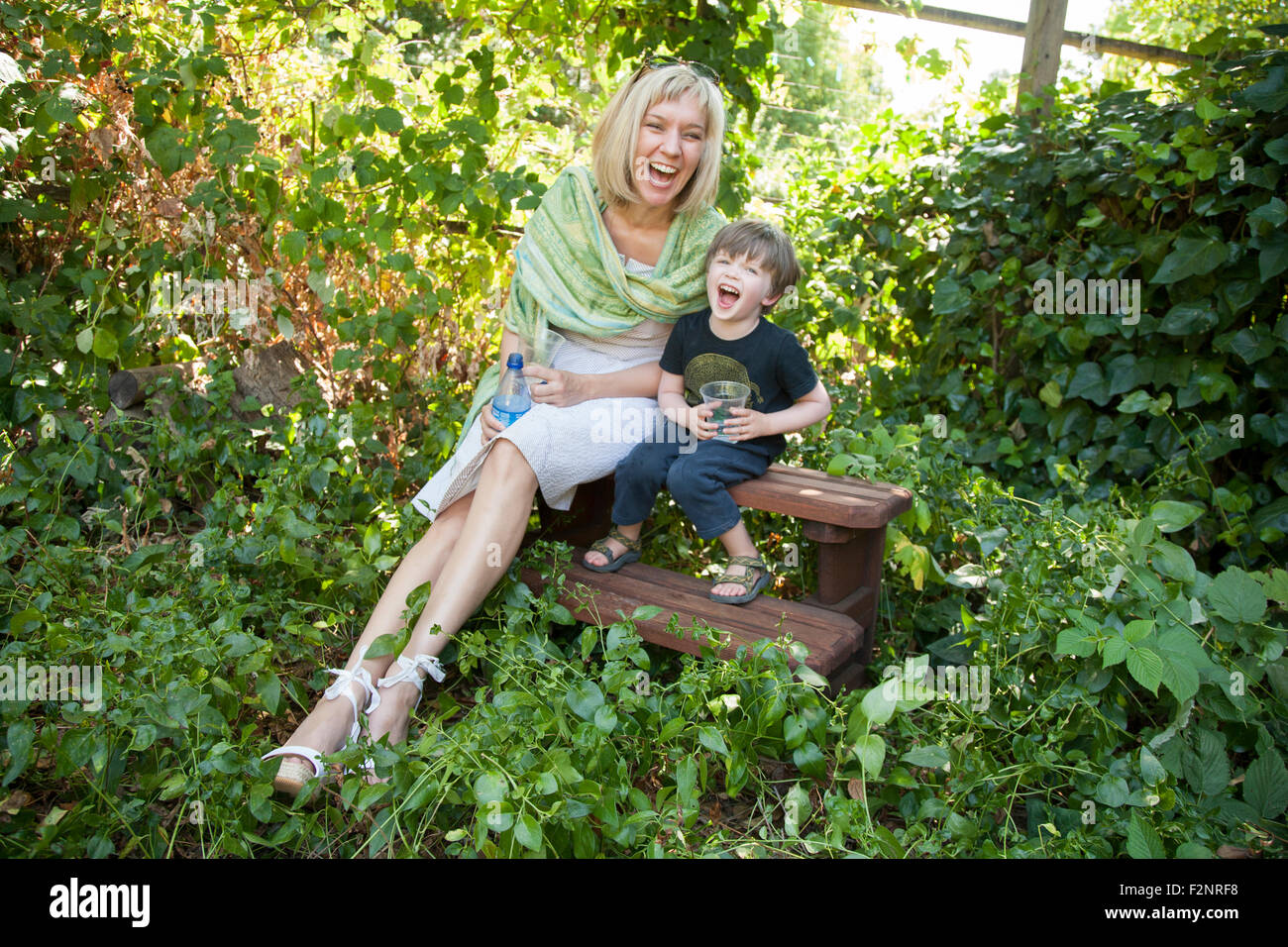 Nonna caucasica e nipote seduti in giardino Foto Stock