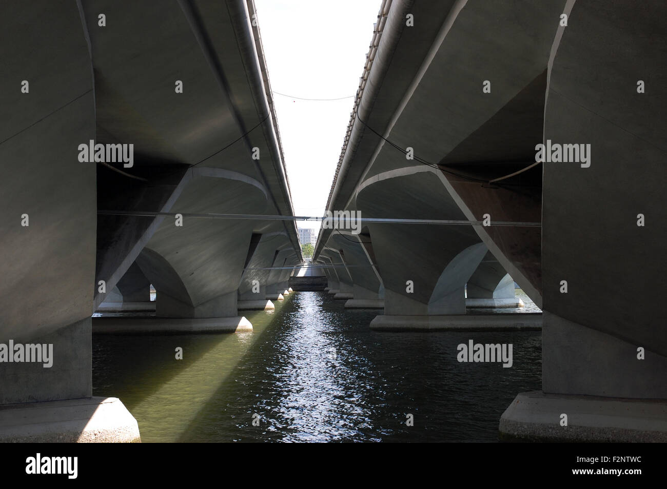 Simmetria di ponti. Guardando verso il basso al centro di due ponticelli costituenti Esplanade Drive attraversando il Fiume Singapore, dal di sotto Foto Stock