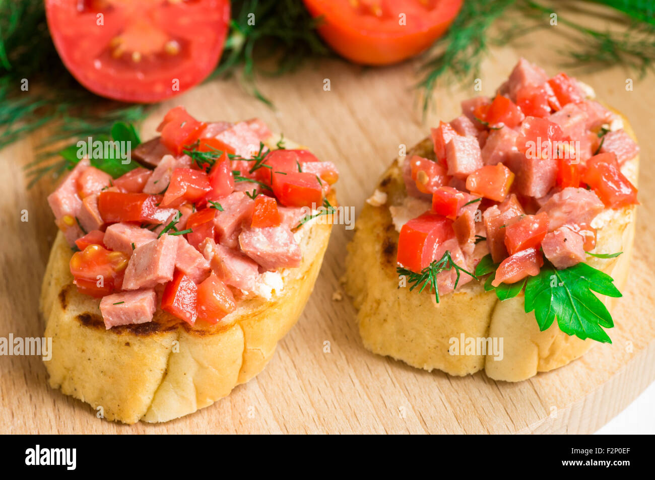 Gustoso antipasto di crostini (crostino) con pomodoro e salsiccia Foto Stock