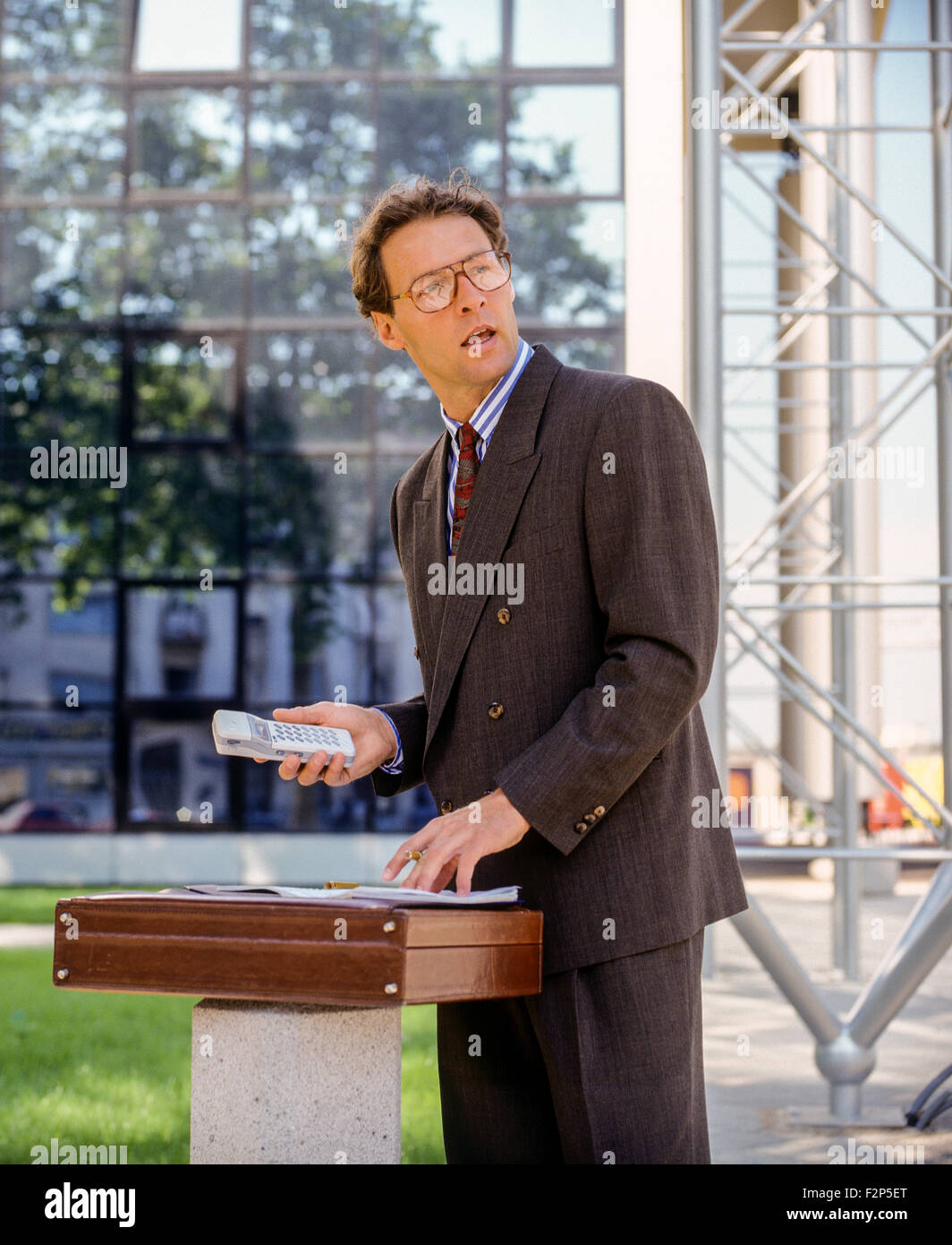 Imprenditore con telefono cellulare di fronte all ufficio edificio Francia Europa Foto Stock