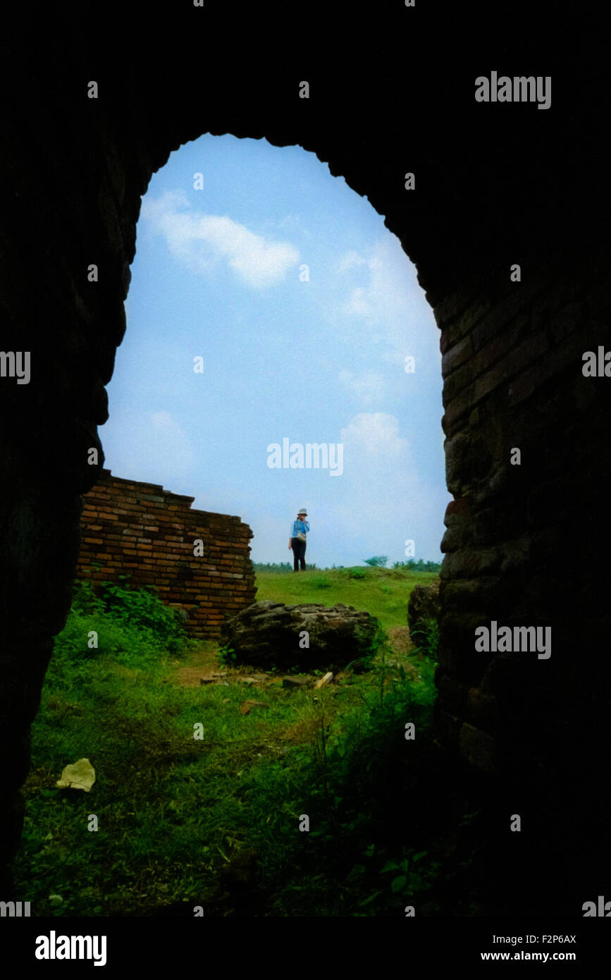 Un visitatore e una rovina del palazzo Surosowan, un patrimonio culturale, sono visti attraverso la porta di una camera in Old Banten, Serang, Banten, Indonesia. Foto Stock