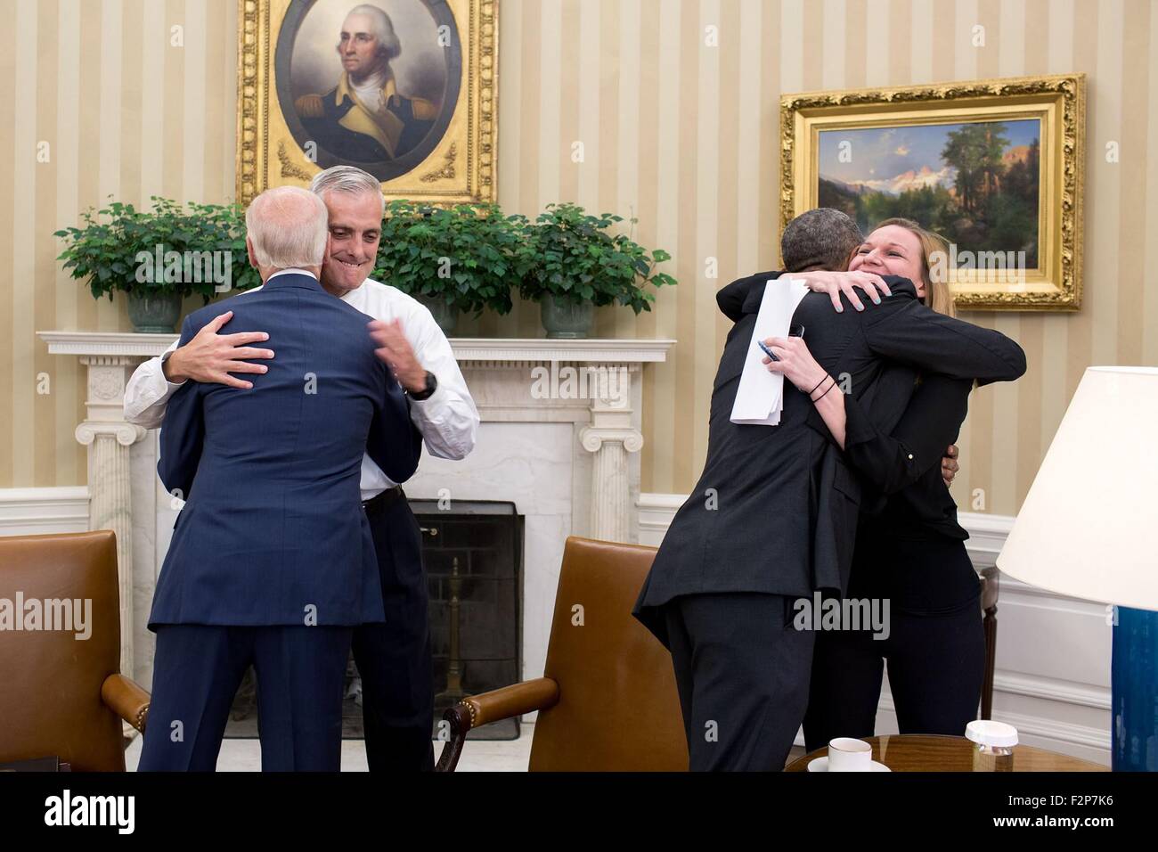 Stati Uniti Il presidente Barack Obama è congratulato da Kristie Canegallo come Vice Presidente Joe Biden abbraccia Denis McDonough all Ufficio Ovale della Casa Bianca dopo che la Corte suprema si è pronunciata a favore della cura conveniente agire Giugno 25, 2015 a Washington, DC. Foto Stock