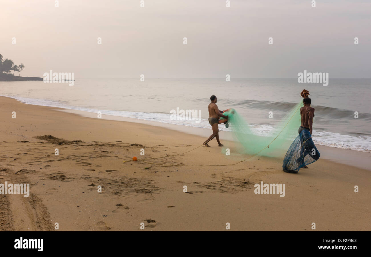 I pescatori preparano net per colata in acque del Mare Arabico fuori dalla spiaggia al villaggio Thottada all'alba. Foto Stock