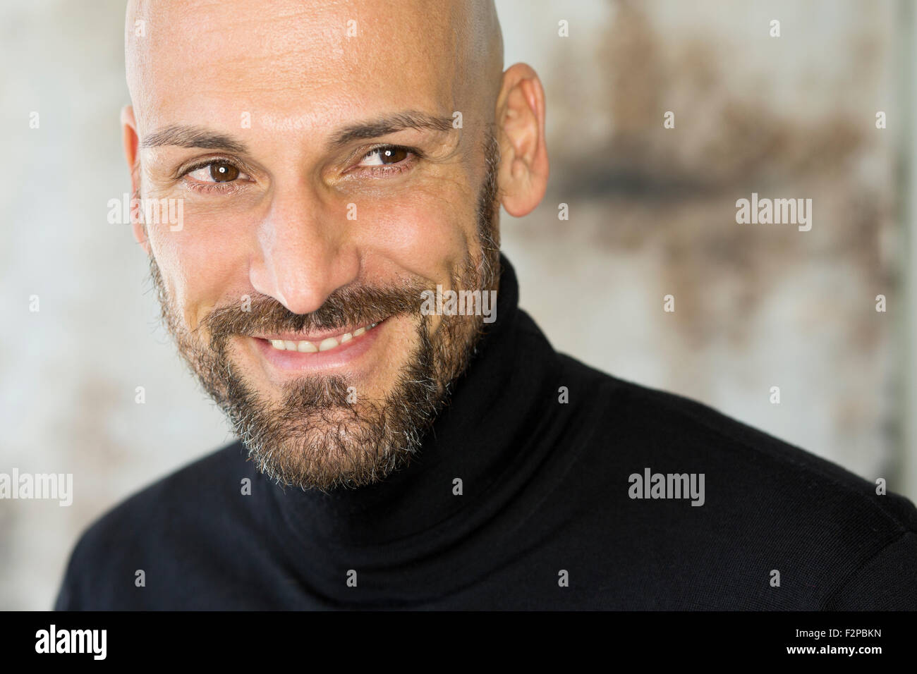 Ritratto di uomo sorridente indossando turtleneck nero Foto Stock