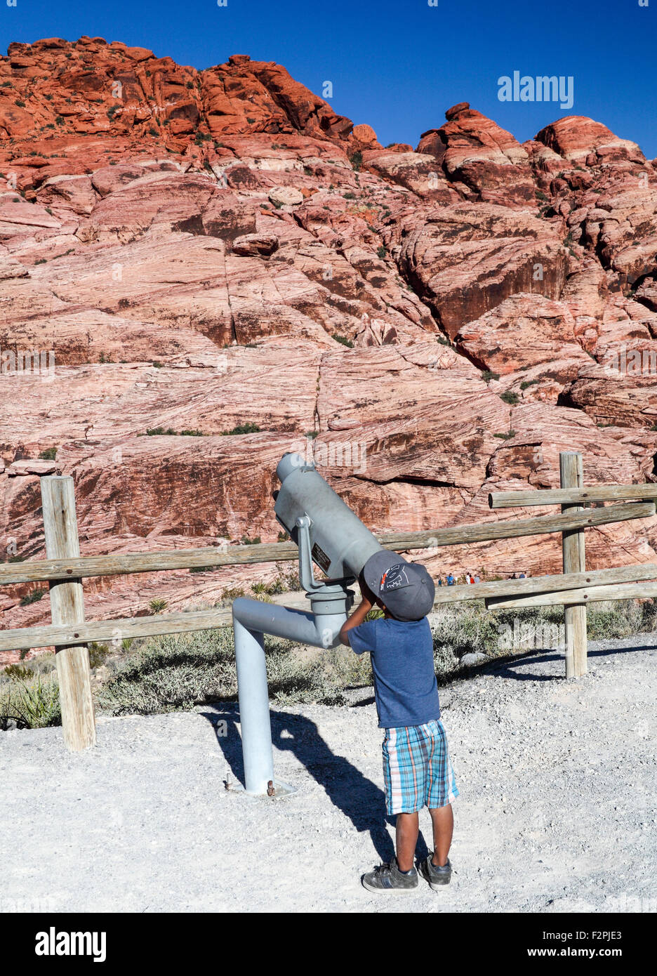 Ragazzo cerca attraverso il telescopio per ottenere una buona vista della Red Rock Canyon National Conservation Area, circa 20 miglia dal Las Vegas Foto Stock