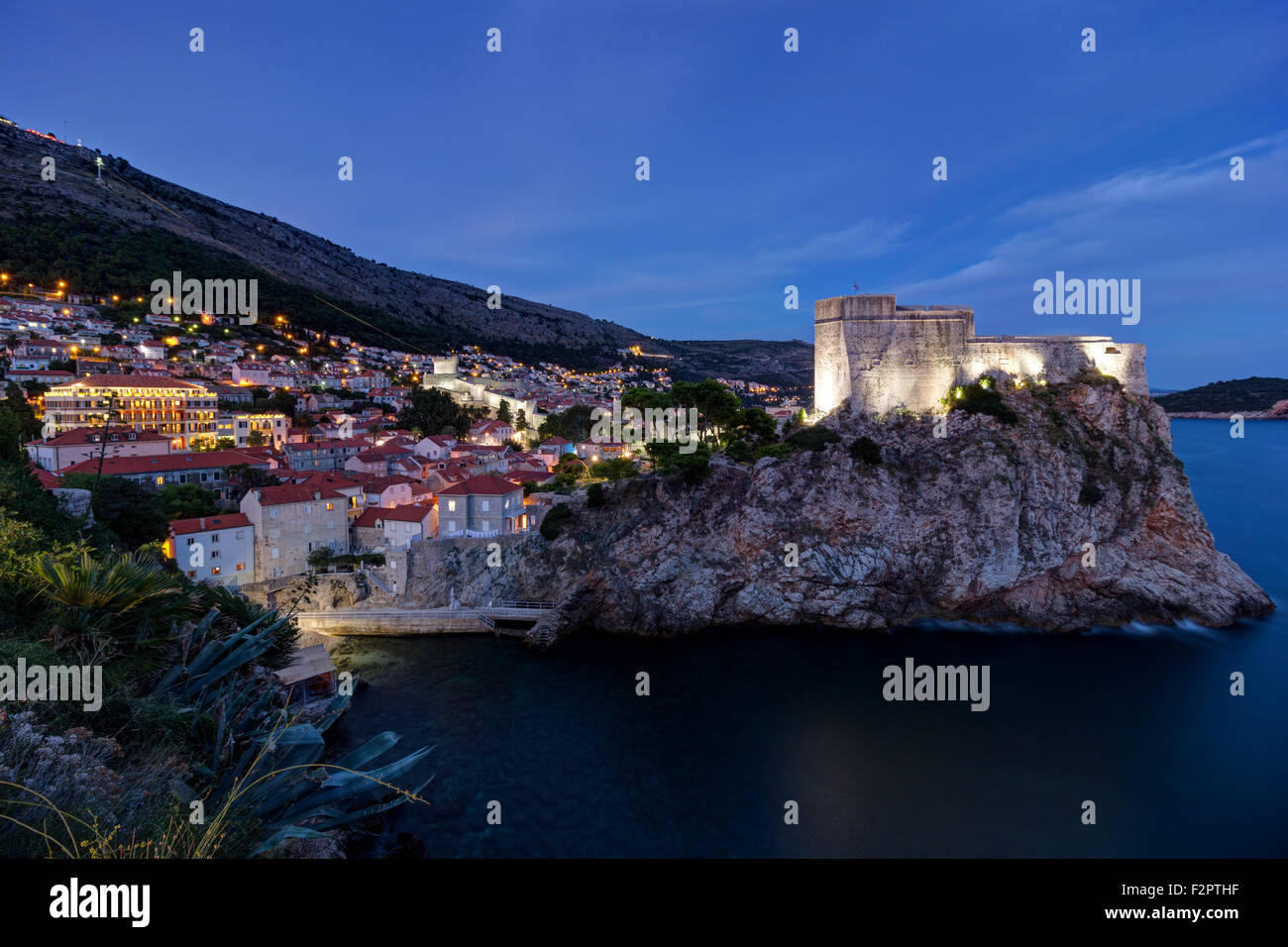 Vista di Fort Lovrijenac (St. Lawrence fortezza) sulla cima di una scogliera ripida e la città di Dubrovnik in Croazia nel buio. Foto Stock