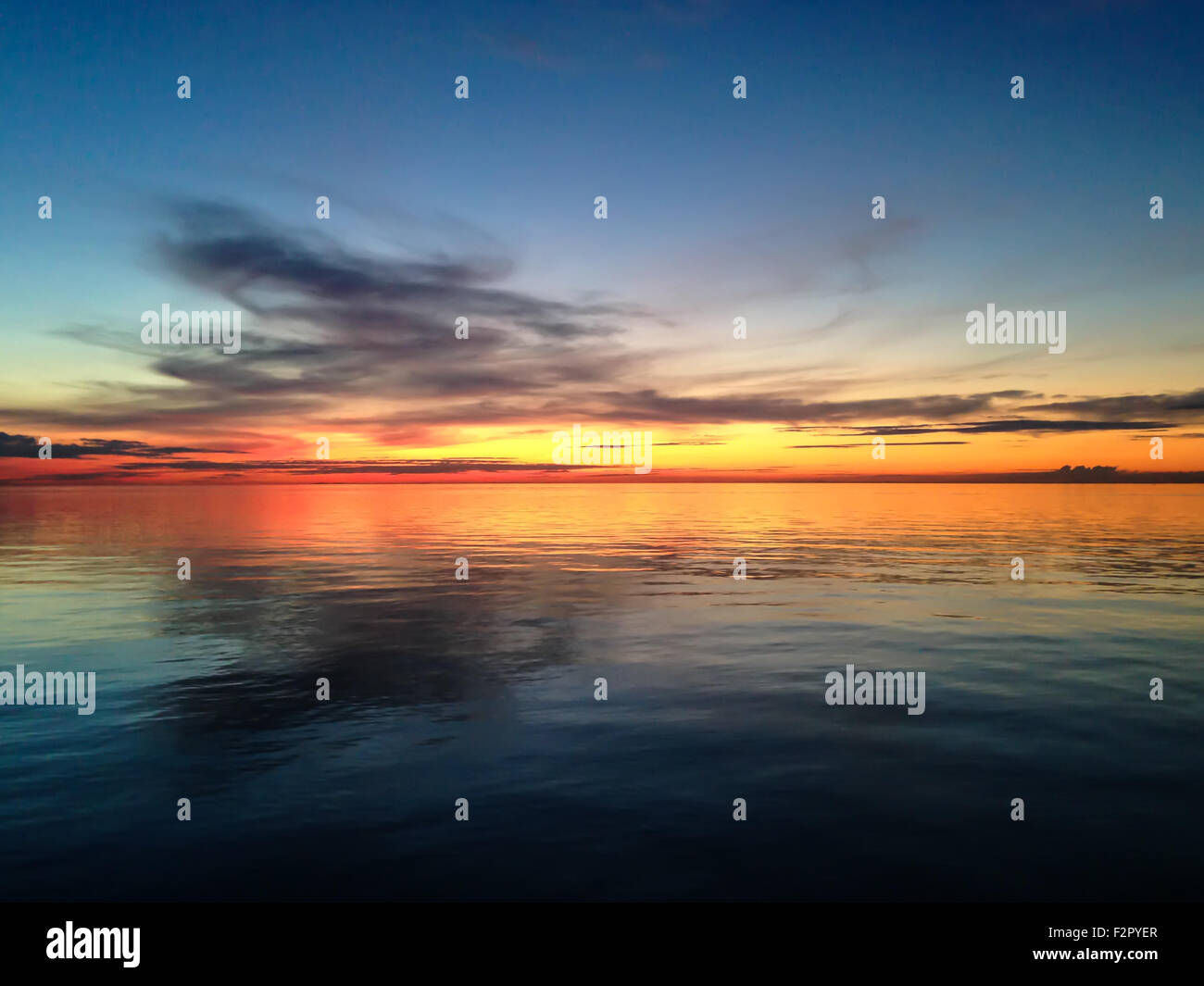 Acqua liscia superficie in arancione tramonto Colori Foto Stock