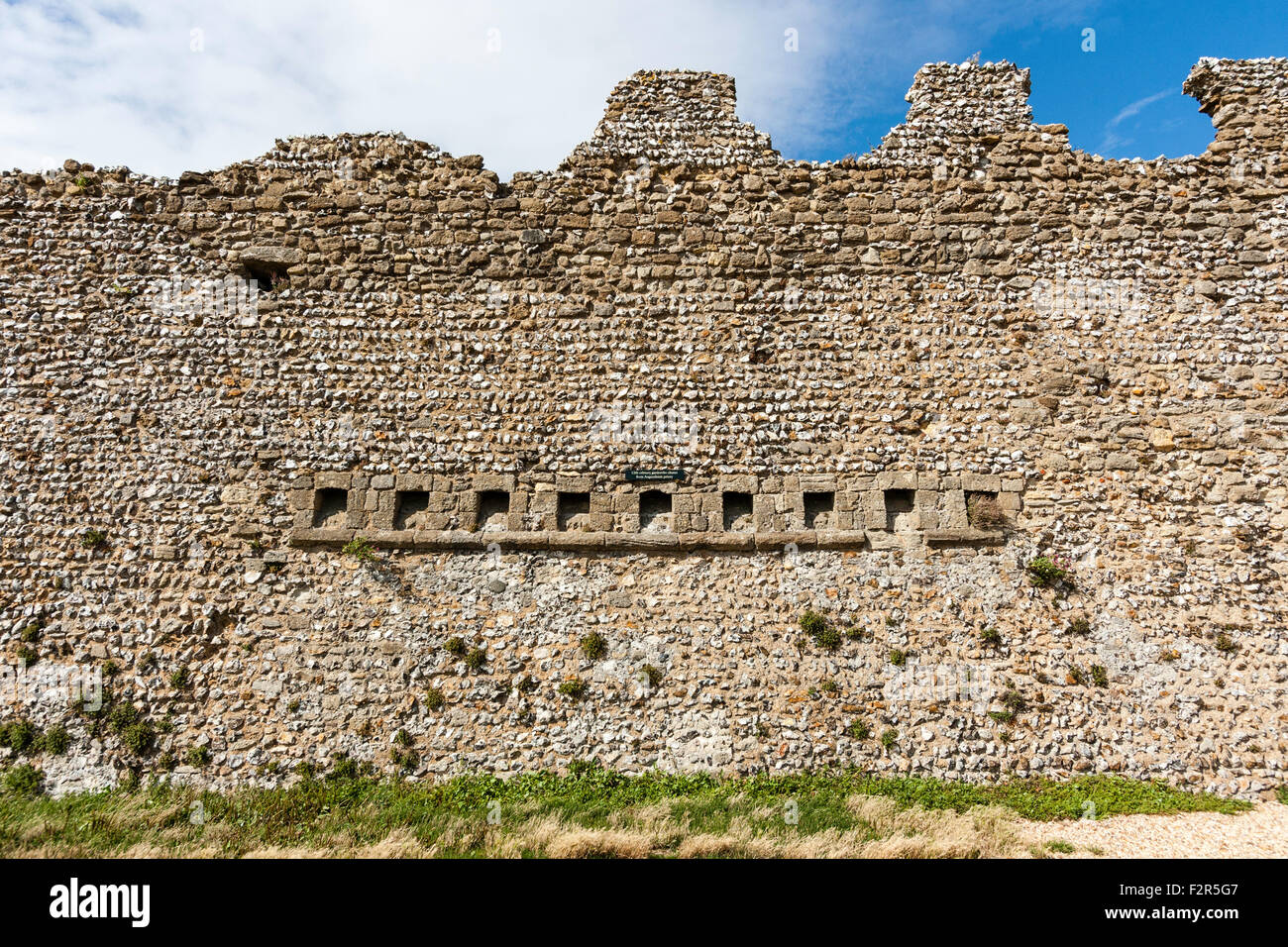 In Inghilterra. Portchester Castle. Portus Adurni, Romana Saxon Shore fort. Xii secolo latrine monastica guardaroba scivoli nella faccia esterna del muro romano Foto Stock