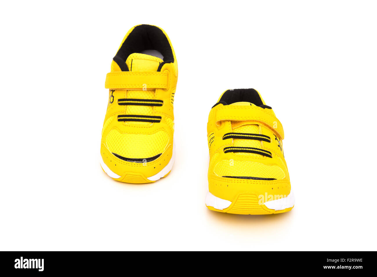 Coppia di giallo scarpe sportive per bambini su uno sfondo bianco Foto Stock