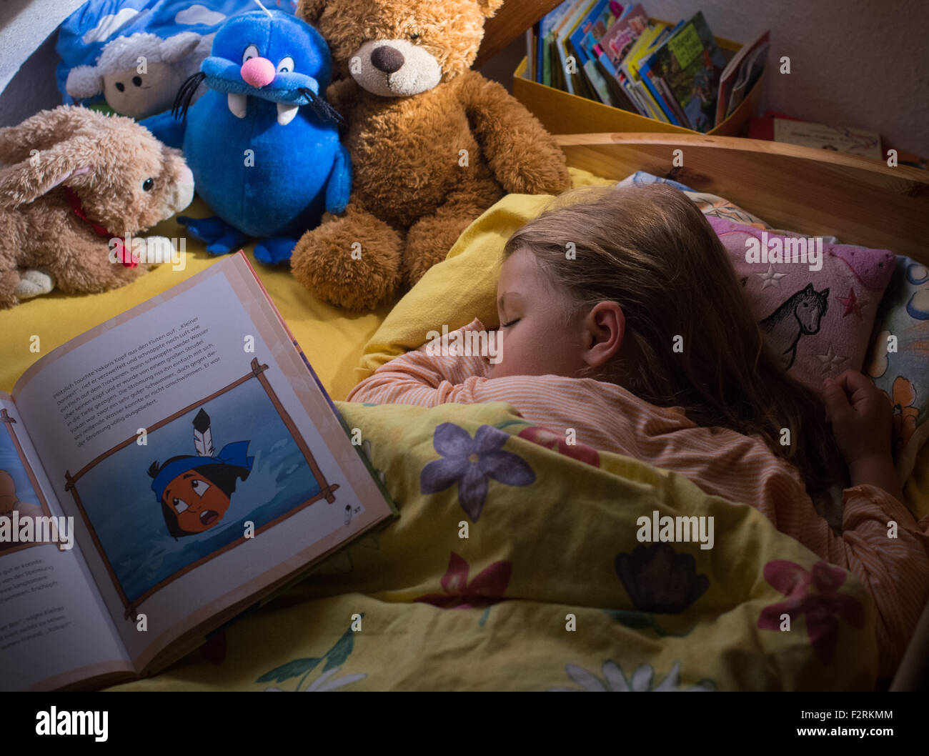 Una bambina di cinque anni dorme nel suo letto mentre un libro per bambini giace sul suo mantello in Sieversdord (Brandeburgo), Germania, 13 settembre 2015. Foto: Patrick Pleul/dpa Modello rilasciato Foto Stock
