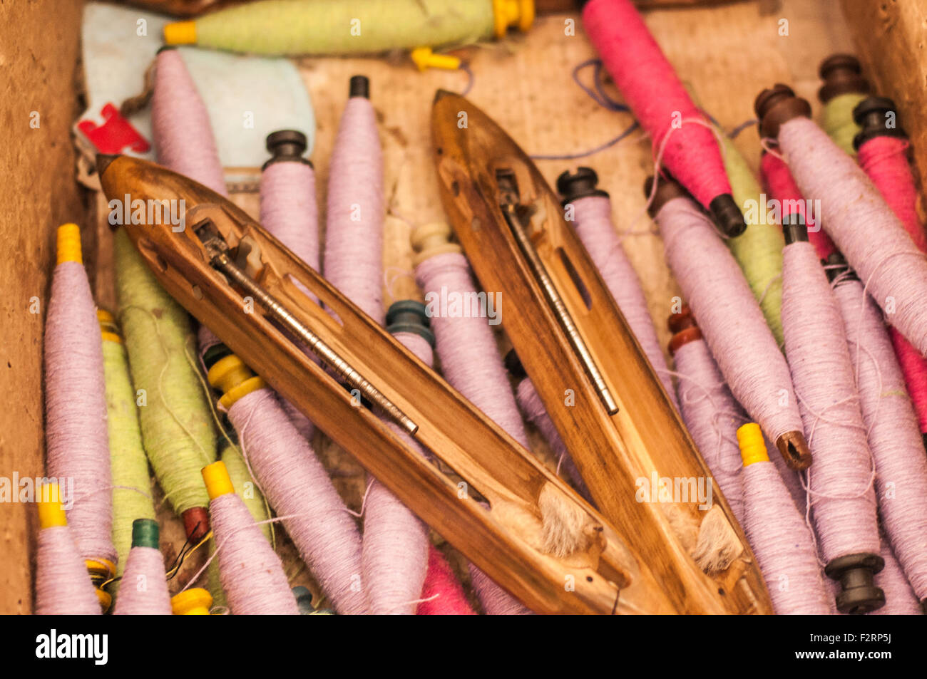 Un mucchio di telaio navette e bobine di filato. Foto Stock