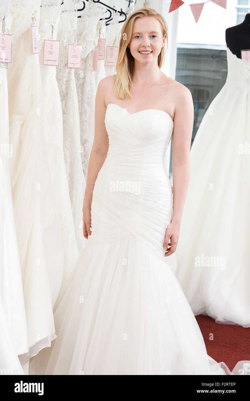 Sposa cercando in abito da sposa in Boutique Nuziale Foto Stock