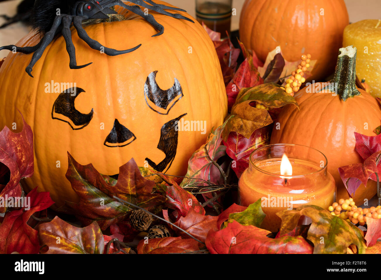 Dipinto la faccia di zucca con lo zucchero zucche e una candela accesa per una Decorazione Halloween impostato Foto Stock