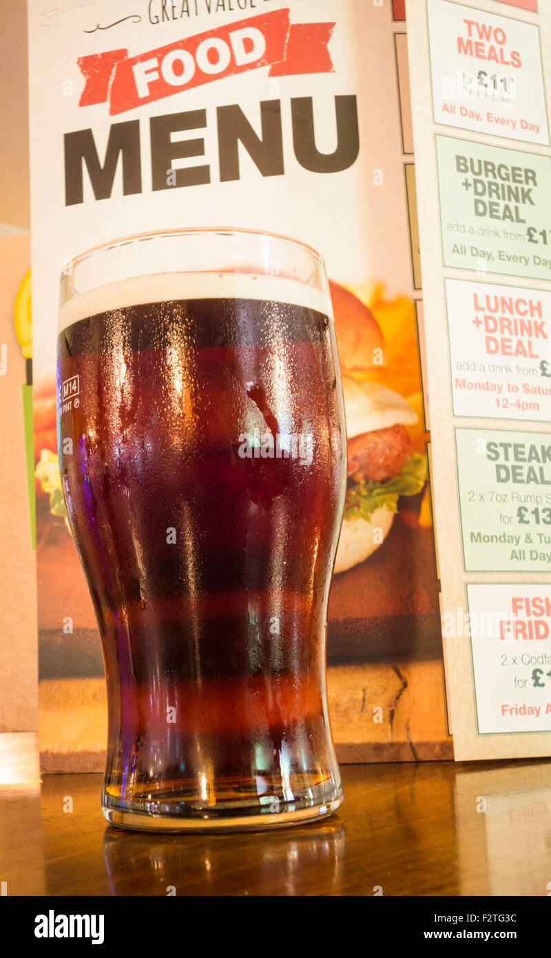 La pinta di birra con menu di cibo in un pub tradizionale in Inghilterra, Regno Unito Foto Stock
