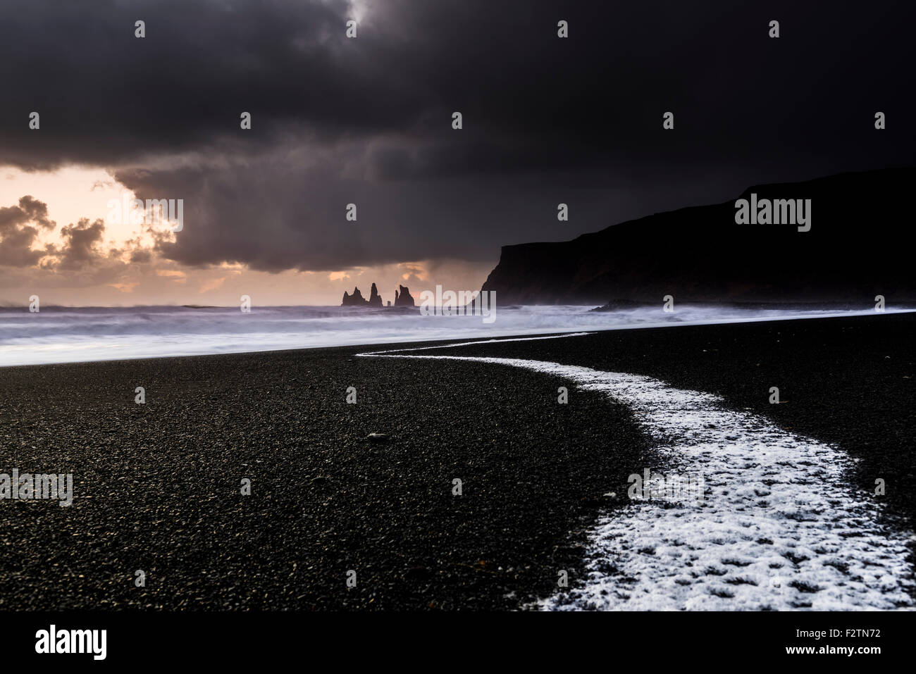 Spiaggia, Reynisdrangar al tramonto con vista oceano surf, sabbia nera, vicino a VIK, Regione meridionale Islanda Foto Stock