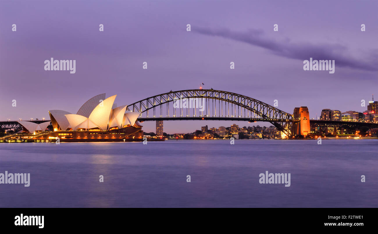 Sydney Australia punti di riferimento della città al tramonto illuminati e riflettendo in sfocato acque del porto di Sydney Foto Stock
