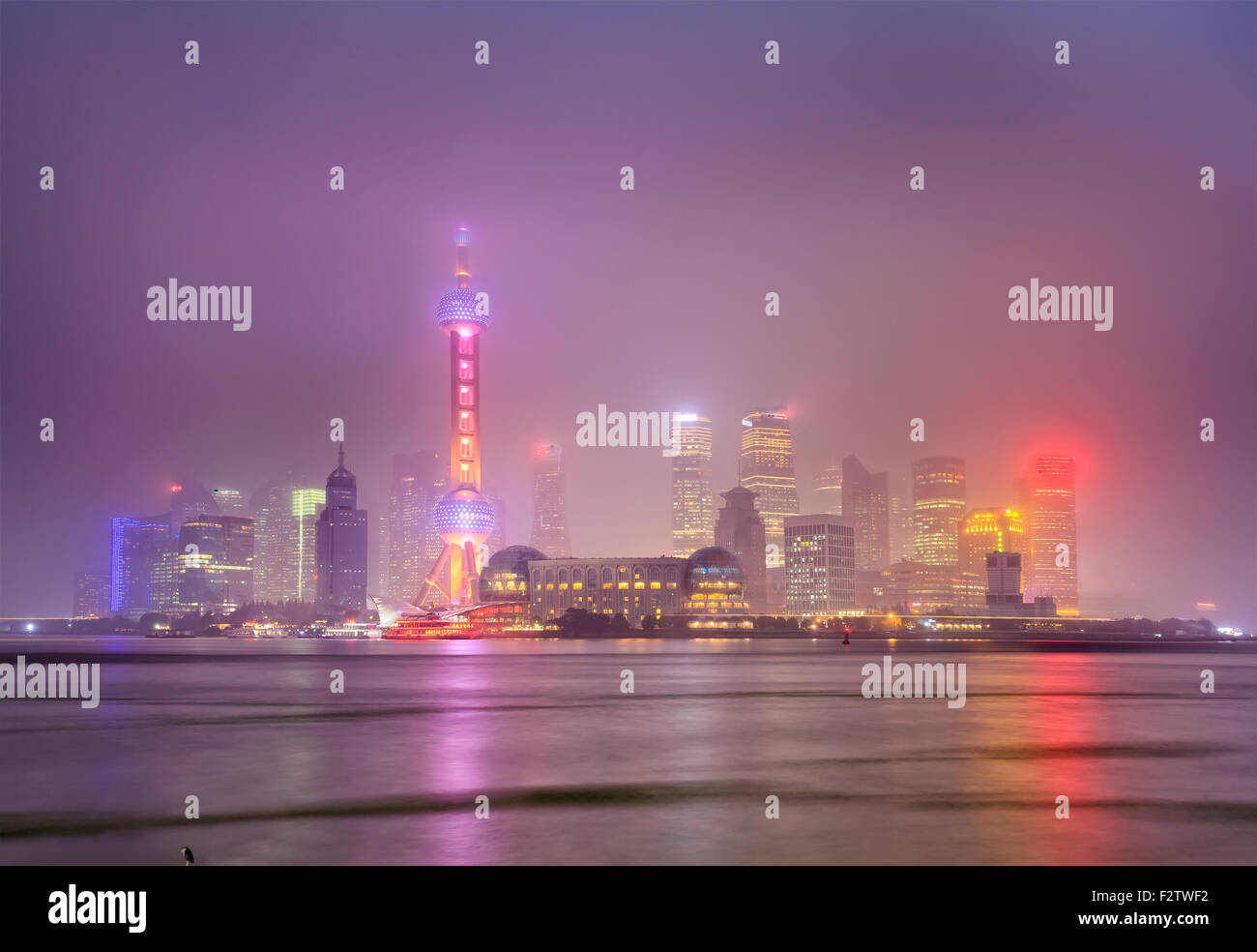 Cinese megapolis moderna Shanghai - vista al tramonto verso il Pudong illuminato da luci con la riflessione in rive dello Yangtze Foto Stock