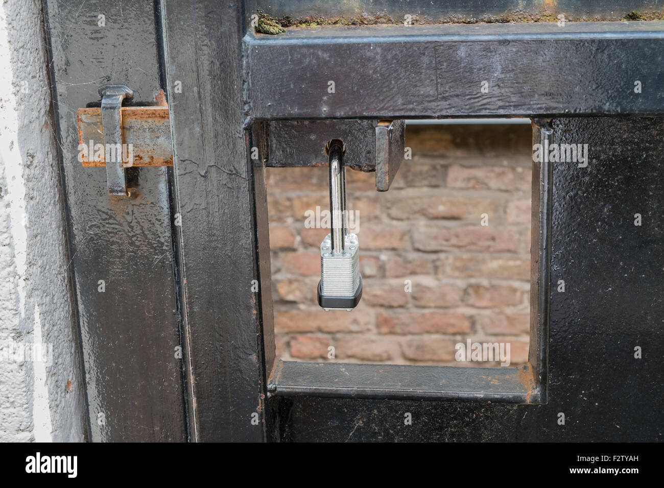 Porta di metallo fissata e bloccata da un lucchetto in metallo Foto Stock