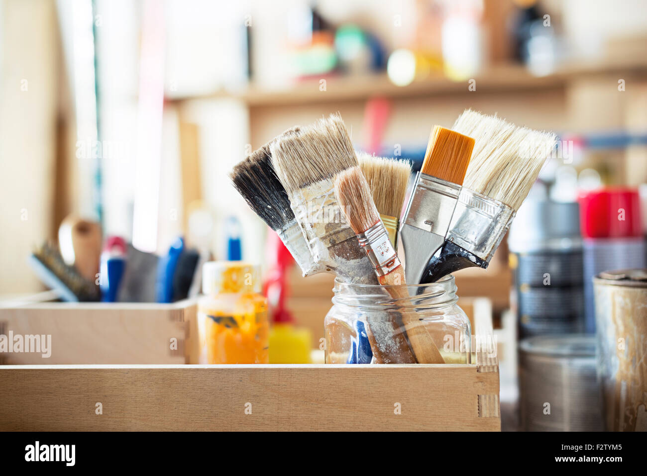 Pennelli per dipingere e la creazione di materiali di consumo in tavola in un workshop. Foto Stock