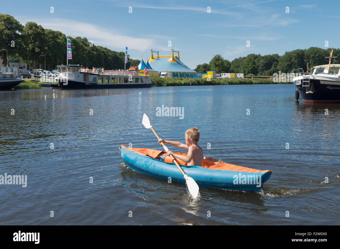 OMMEN, Paesi Bassi - 9 agosto 2015: il ragazzo sconosciuto a giocare con la sua canoa nel fiume regge. La Regge area è una famosa per le vacanze Foto Stock