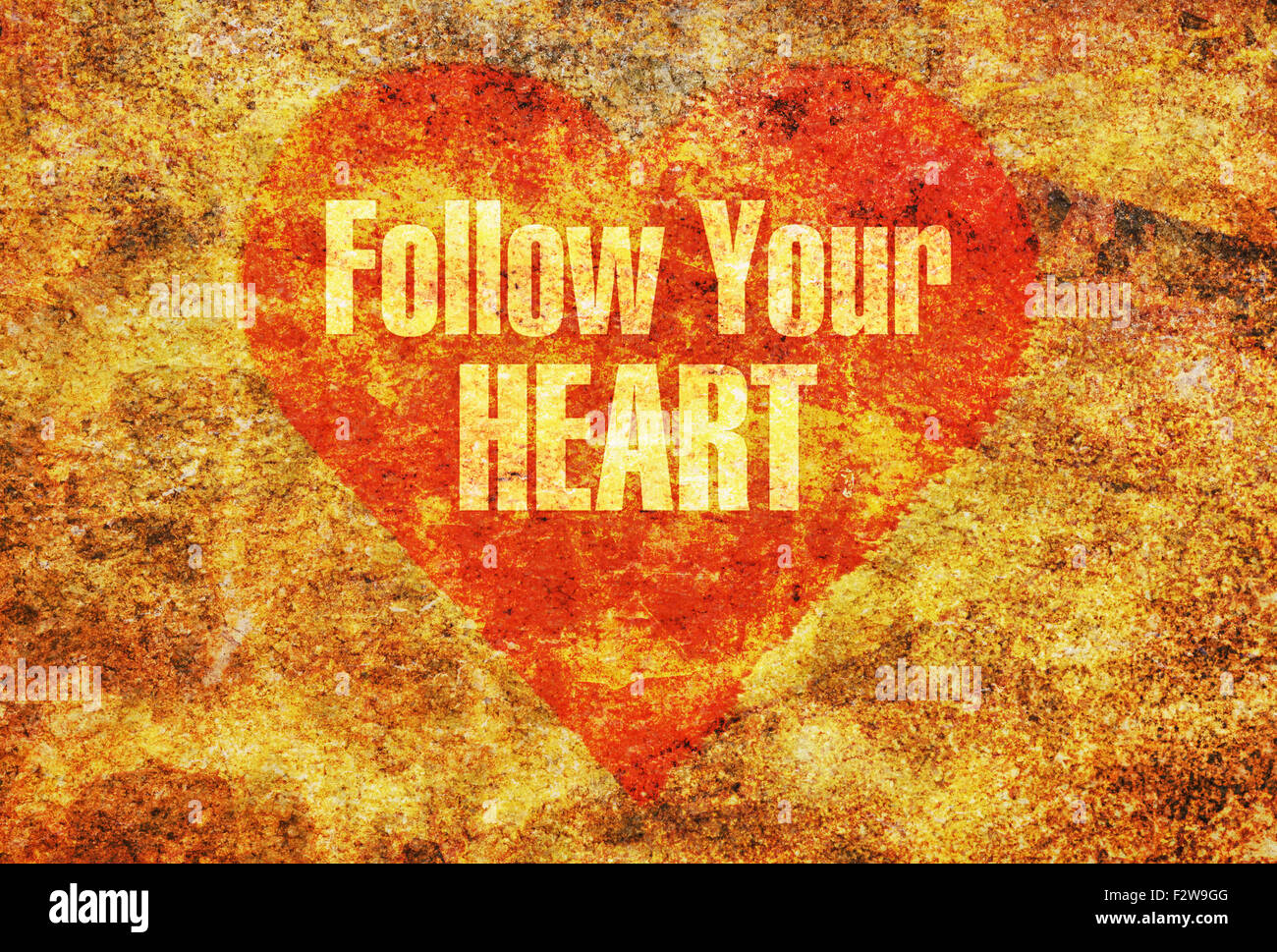 Testo Segui il tuo cuore scritto con lettere dorate su un cuore rosso Foto Stock