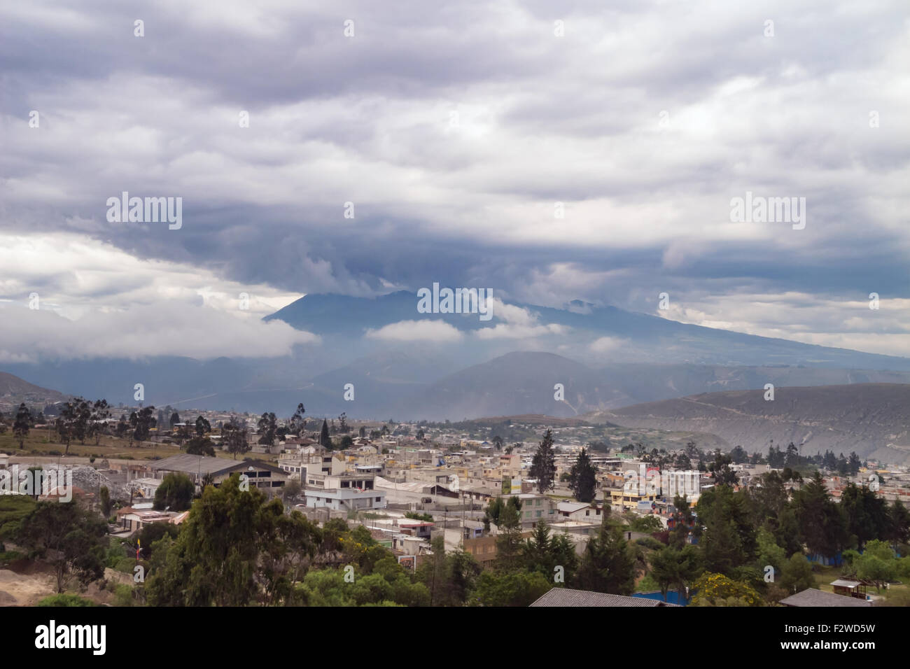 Heavy Weather raccogliendo attorno i vulcani che circondano Quito. Di Haze e di perturbazioni atmosferiche attenua la messa a fuoco Foto Stock