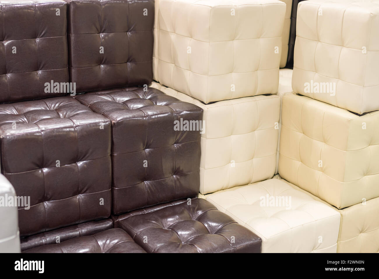 Molti footstools in pelle di diversi colori in pila Foto Stock