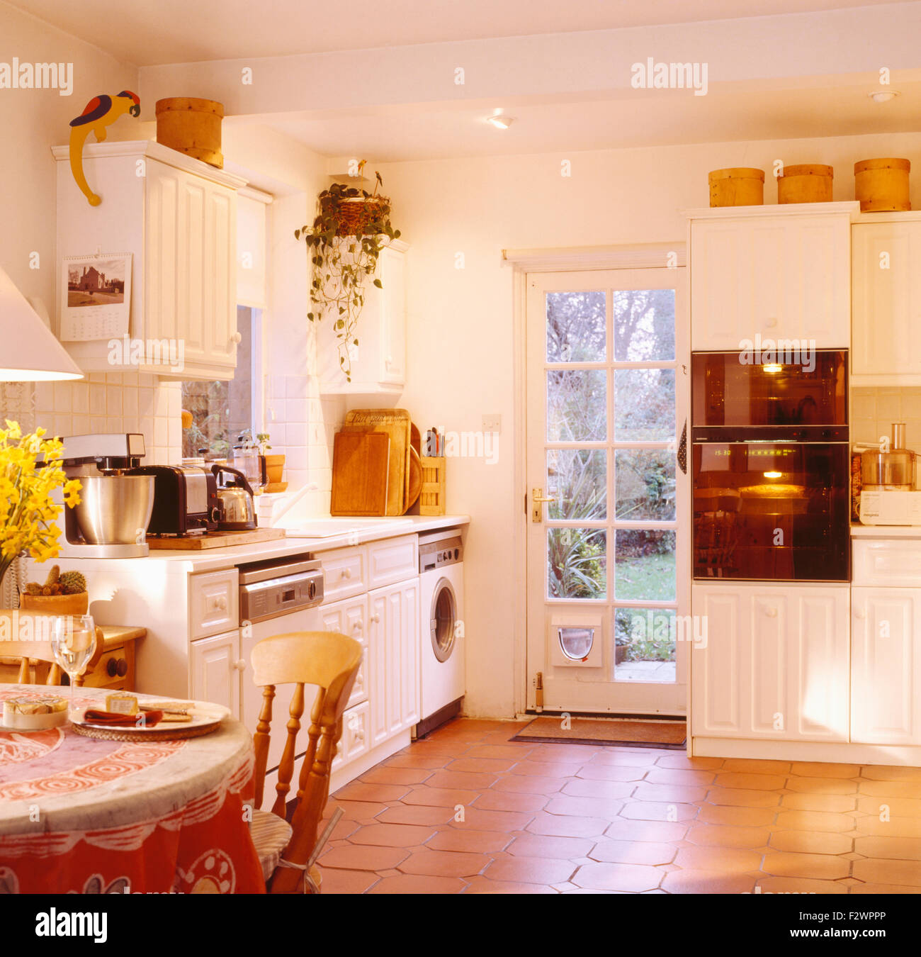 Pavimento in piastrelle di terracotta degli anni novanta in cucina con  occhio-forni di livello Foto stock - Alamy