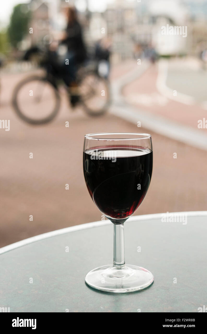 Un bicchiere di vino rosso su un tavolo fuori da un bar in Amsterdam Foto Stock