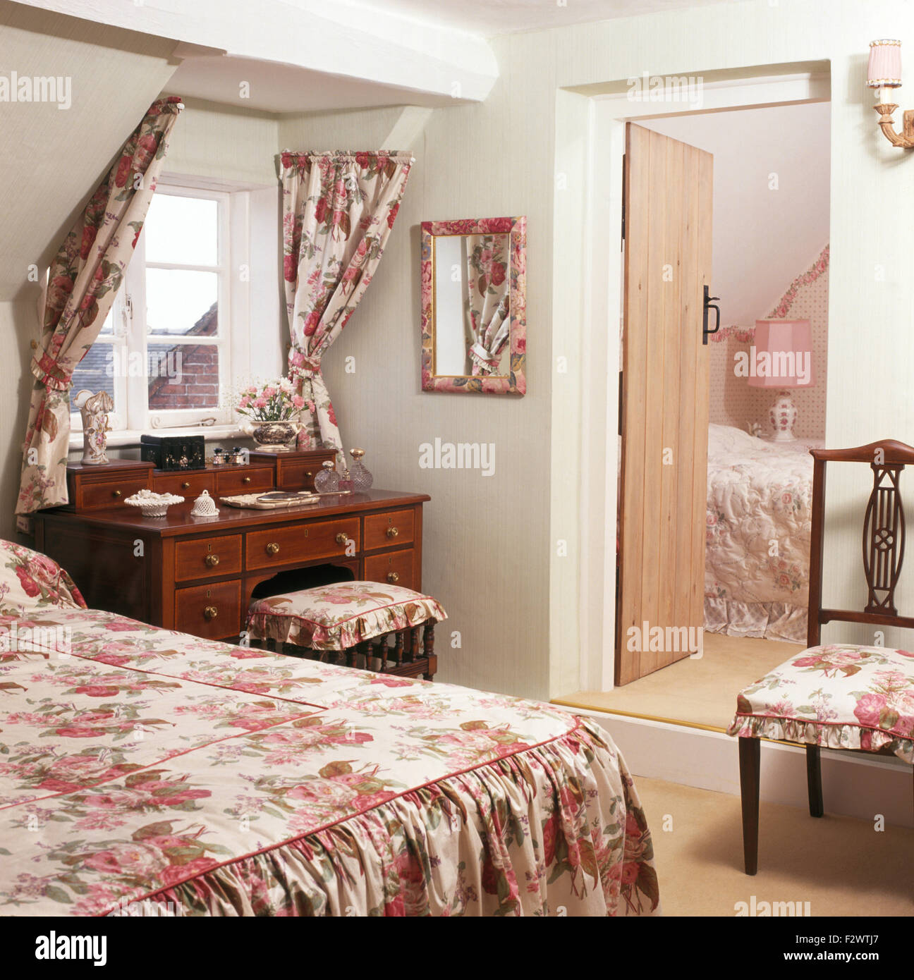 Rosa rosa modellato biancheria da letto e coordinando le tende in mansarda camera da letto Foto Stock