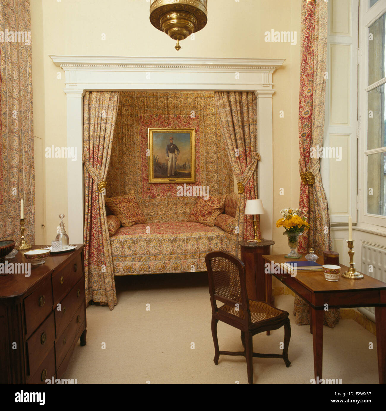 Tende con motivi geometrici su letto alcova in ottanta paese francese camera da letto con mobili antichi Foto Stock