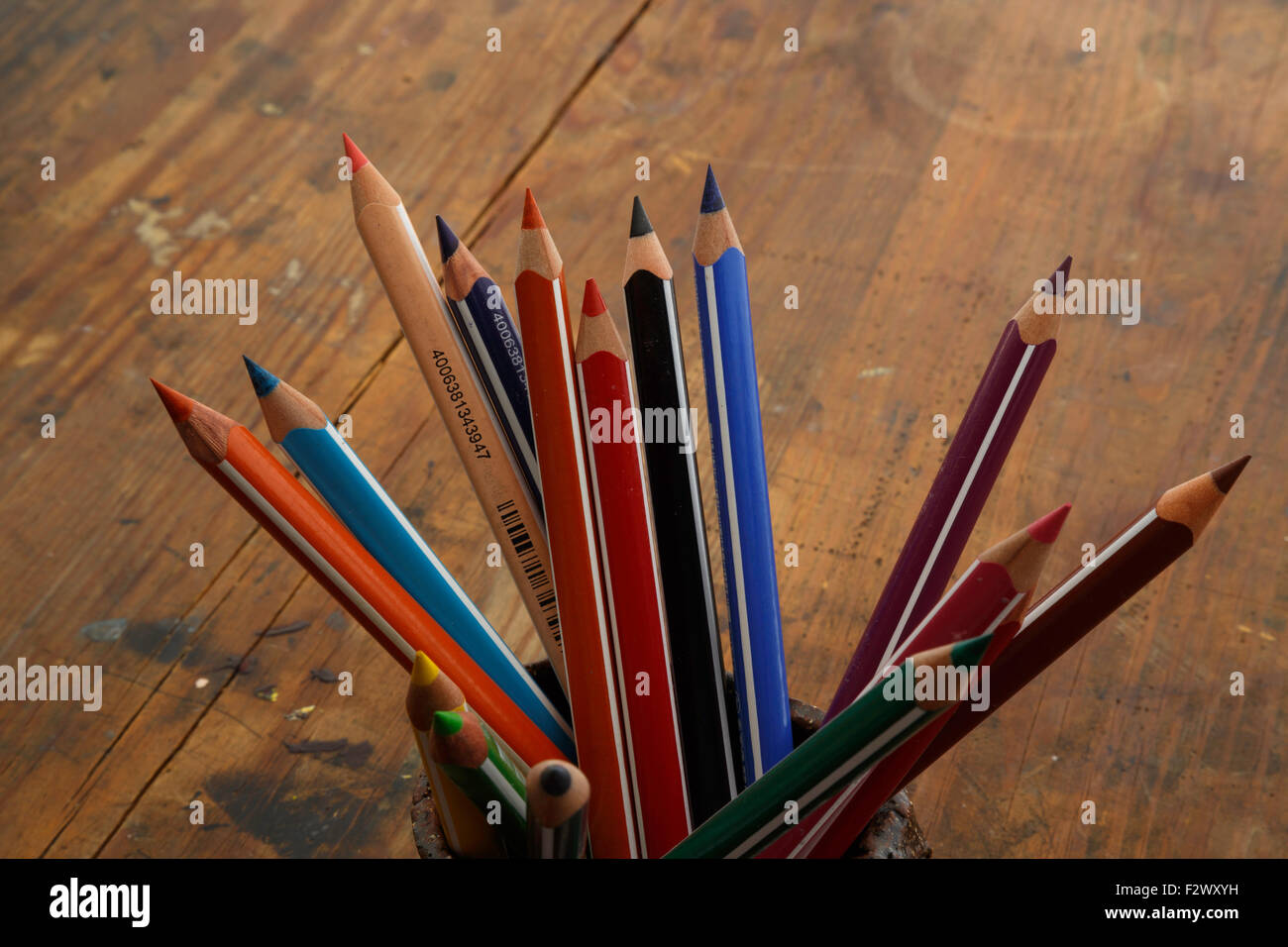 Matite di colore in una tazza in legno tavolo antico. Foto Stock