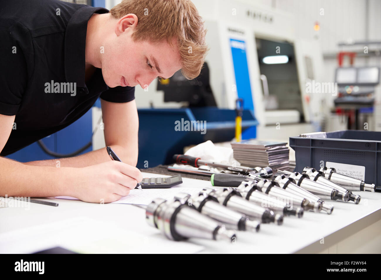 Ingegnere di progetto di pianificazione con macchine CNC in background Foto Stock Ingegnere di progetto di pianificazione con macchine CNC in background Foto Stock