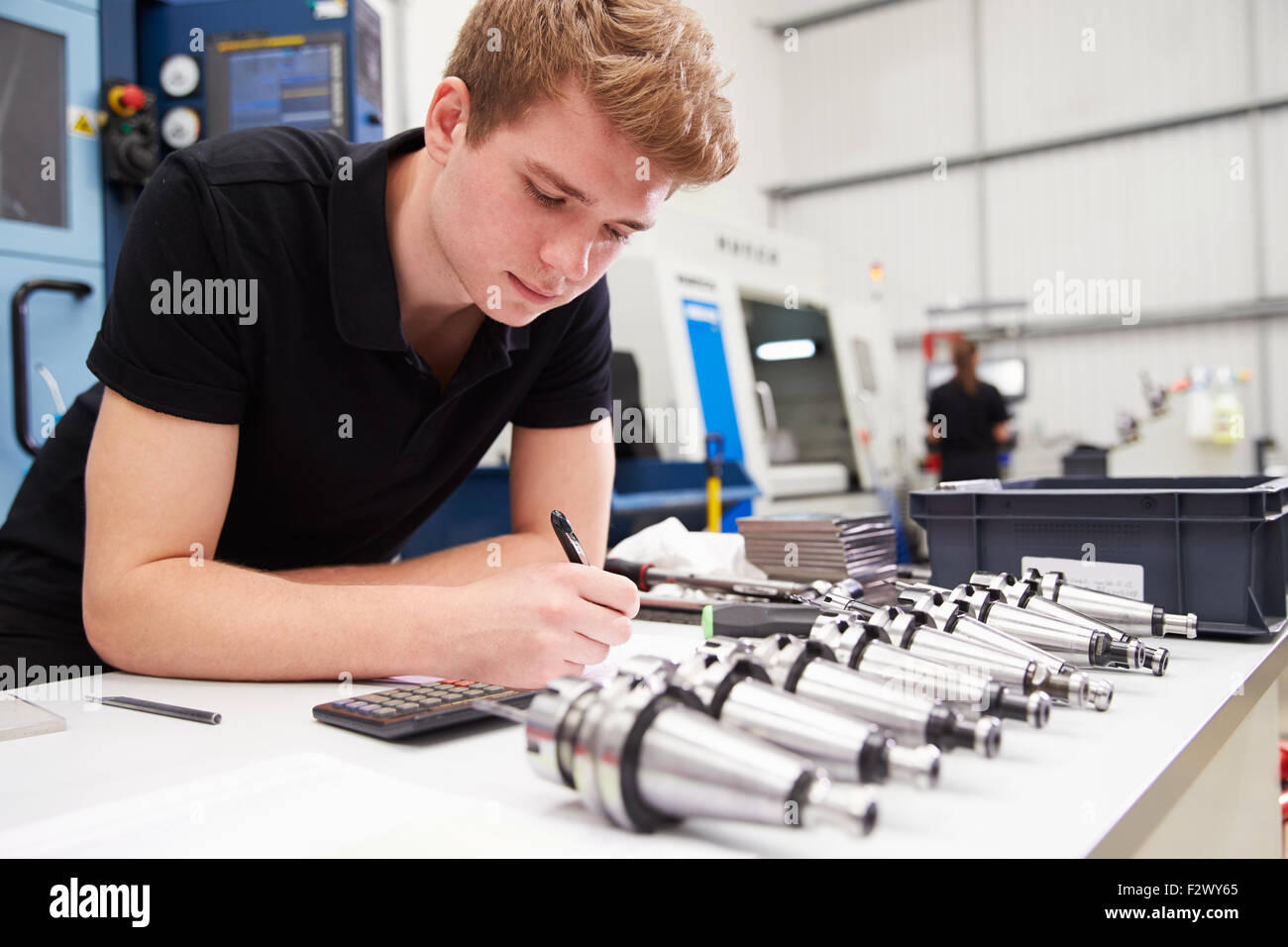 Ingegnere di progetto di pianificazione con macchine CNC in background Foto Stock Ingegnere di progetto di pianificazione con macchine CNC in background Foto Stock
