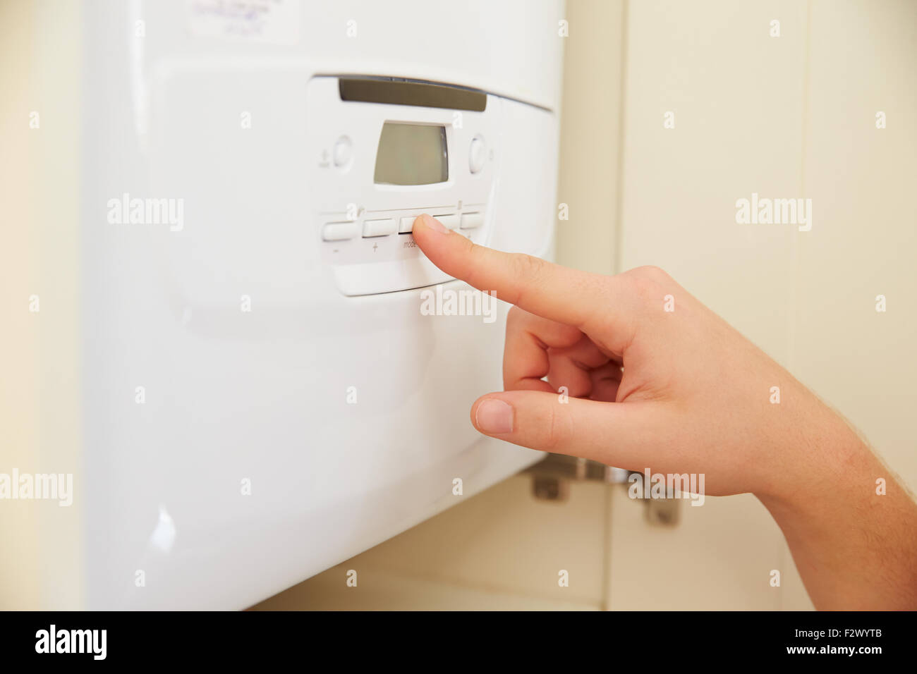 La mano della persona che utilizza caldaia domestica controlla, close up Foto Stock