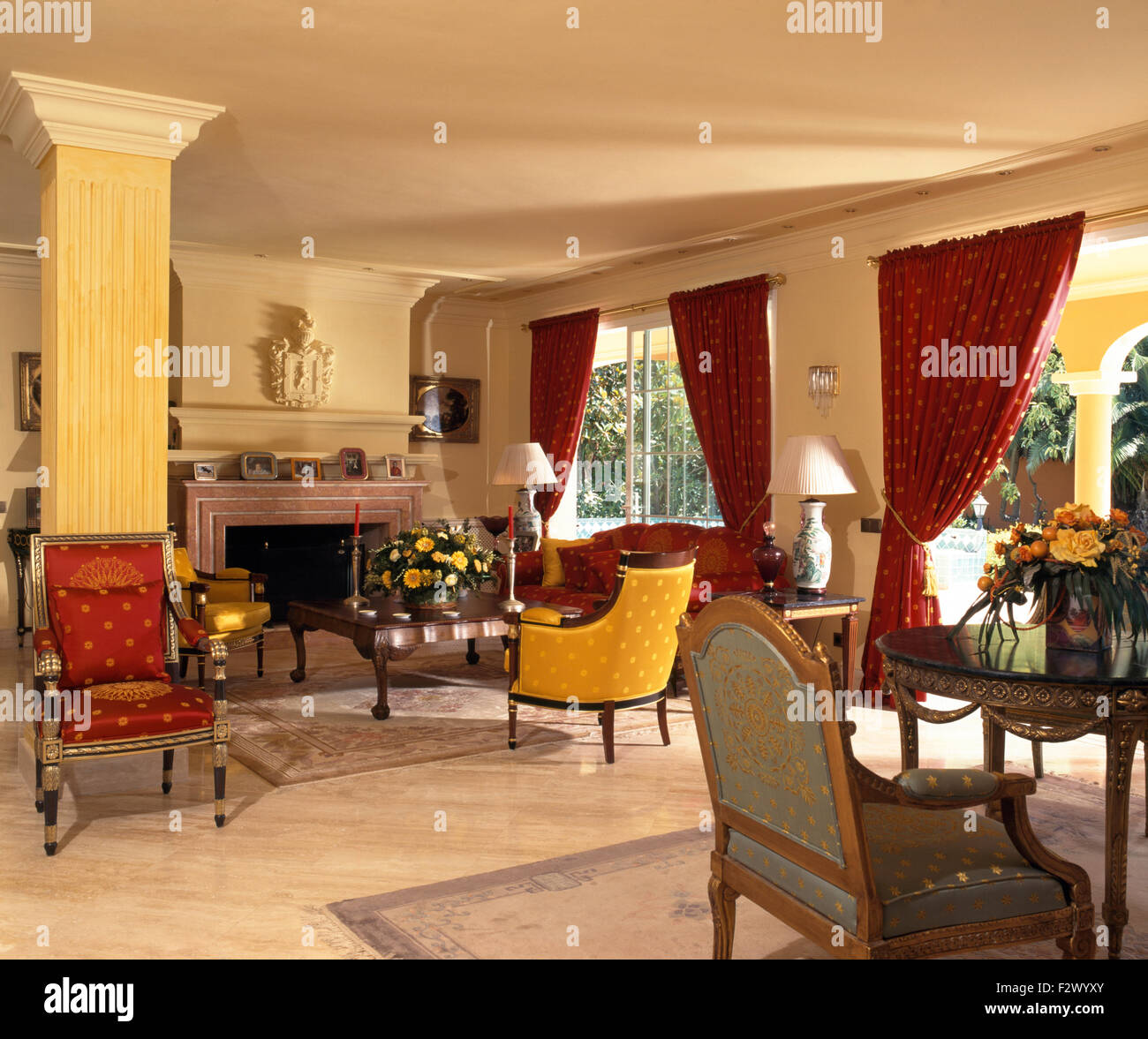 Tende rosse e colorate sedie e divani in spagnolo soggiorno Foto Stock