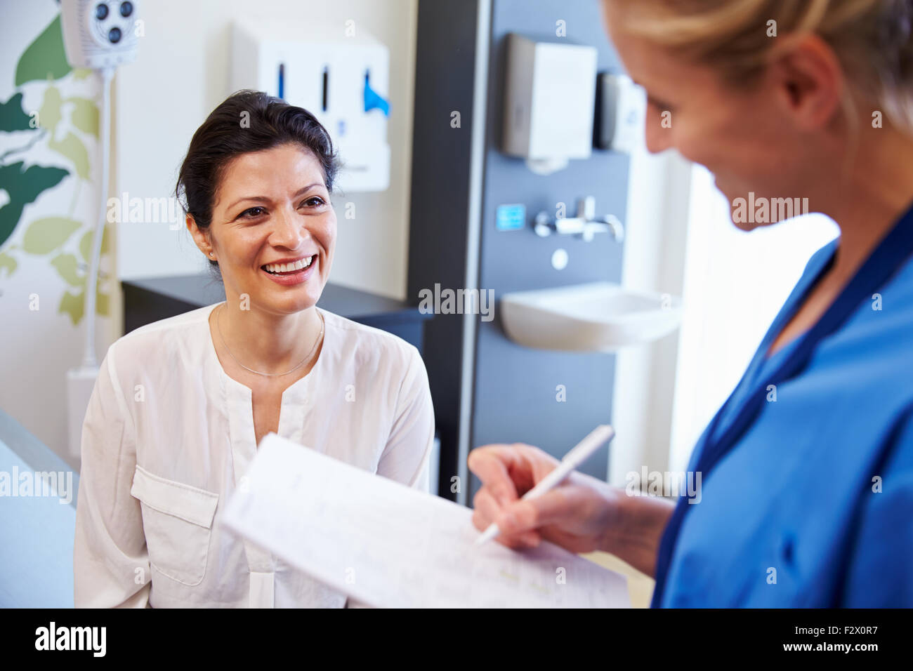 Paziente di sesso femminile e il medico dispone di consultazione nella stanza di ospedale Foto Stock
