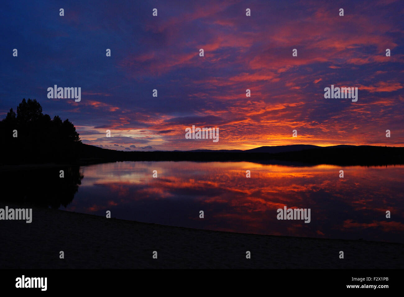 Tramonto colorato con la riflessione di montagna Foto Stock