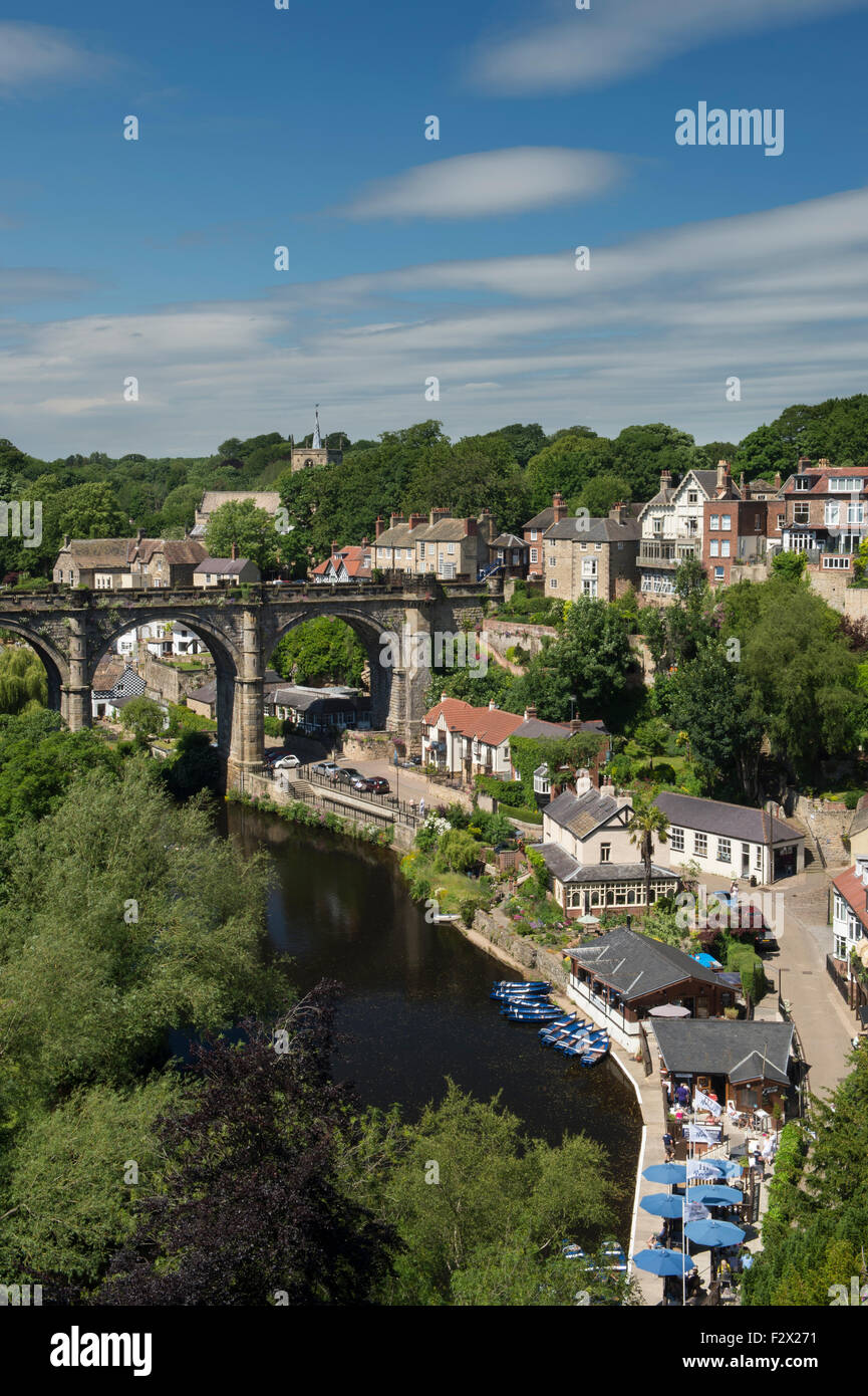 Cielo blu sopra Knaresborough, England, Regno Unito - scenic estiva soleggiata vista del viadotto del ponte sul fiume Nidd, barche, ripida gola boscosa & riverside case. Foto Stock