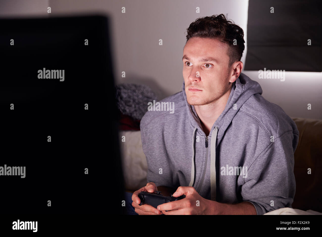 Giovane uomo addicted ai video giochi a casa Foto Stock