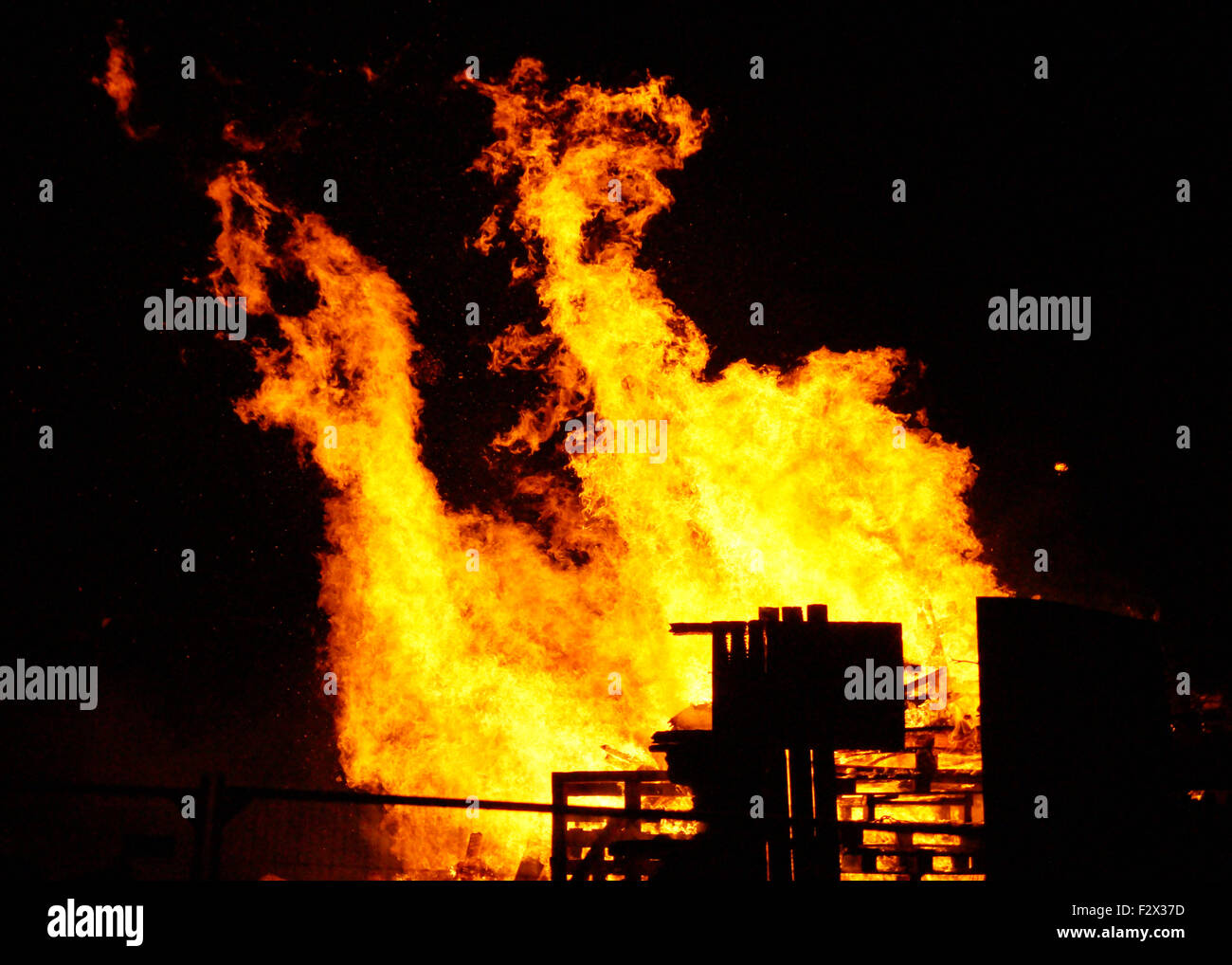 Guy Fawkes notte grandi falò in Strathaven Park il 5 novembre. Arancio e giallo fiamme a leccare il cielo di notte a causa di forti venti Foto Stock