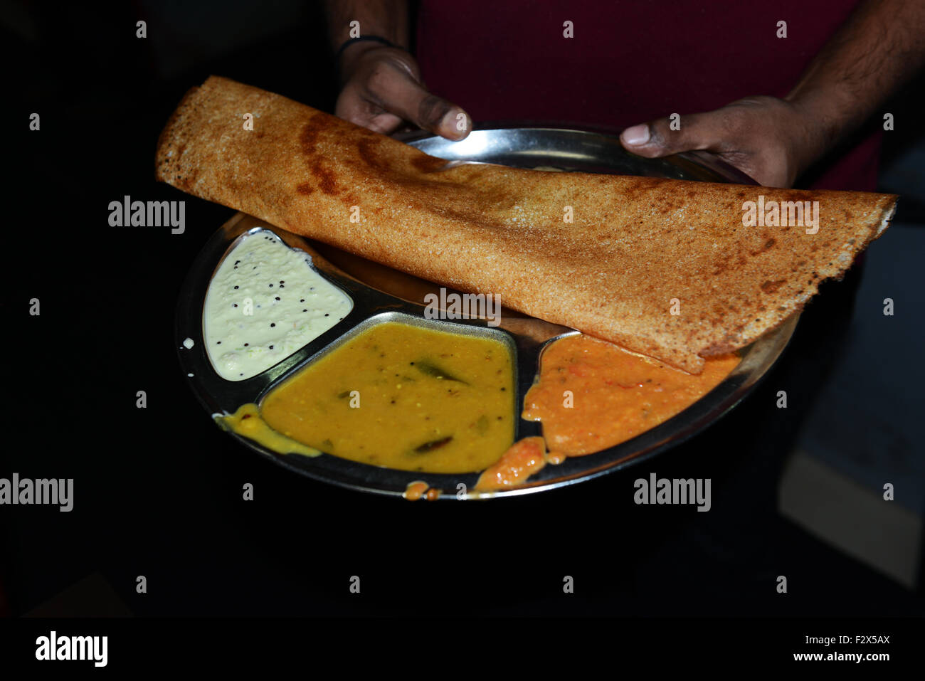 Masala Dosa servita con diversi chutney salsa. Foto Stock