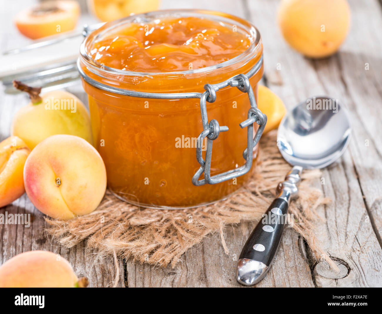 Un vasetto di marmellata di albicocche (close-up shot) con un po' di frutta fresca Foto Stock